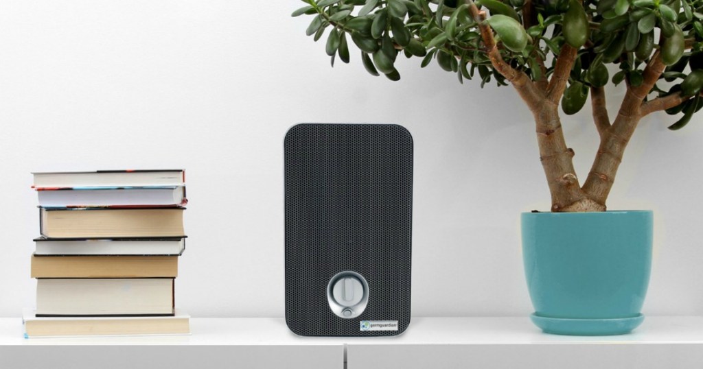 air purifier on table by books and tree