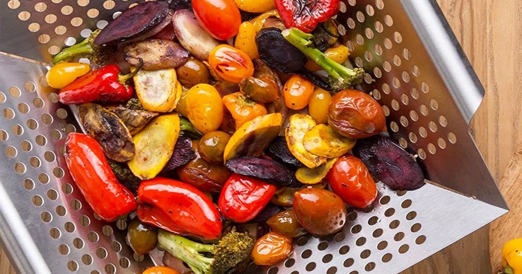 stainless steel grill basket with grilled vegetables inside