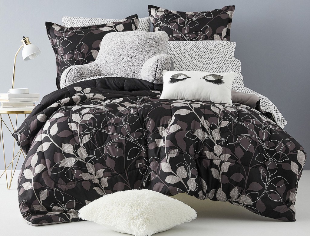 black with white and grey leaves comforter set on bed with matching pillow cases and shams