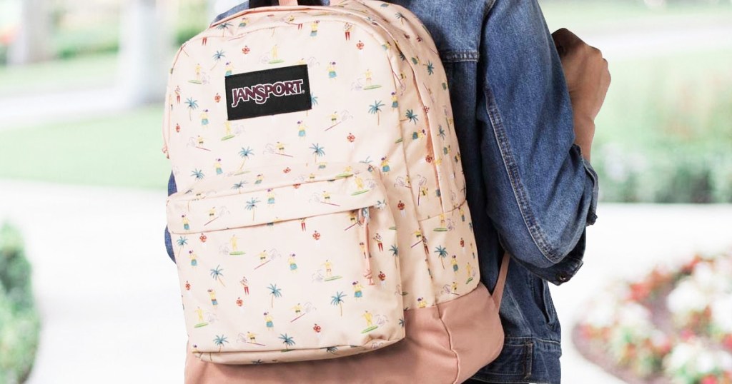 girl in denim jacket with jansport backpack on her back with surfer prints