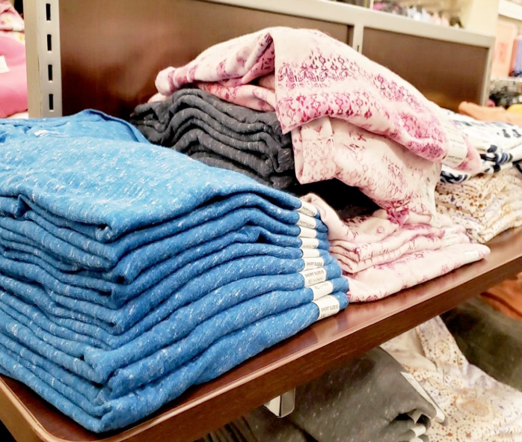 folded women's tees in various colors and prints on a Kohl's store display shelf