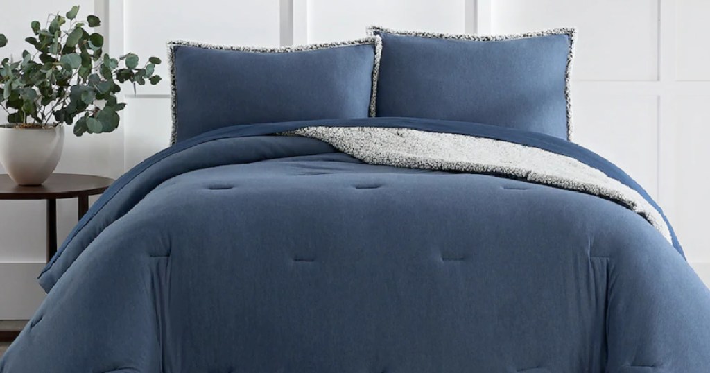 Blue Koolaburra by UGG bedding and shams on a queen size bed next to a nightstand