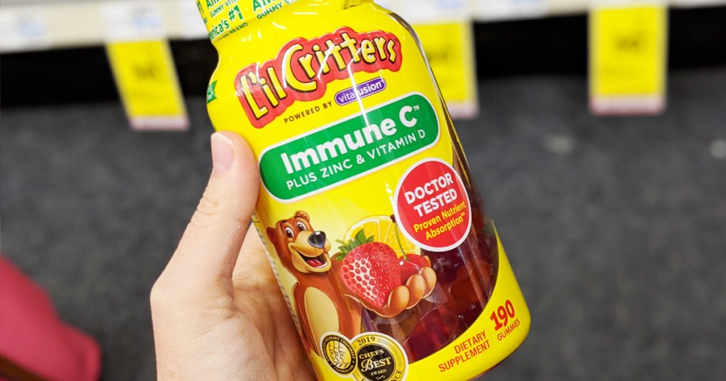 person holding a yellow bottle of lil critters immune C kids gummy vitamins