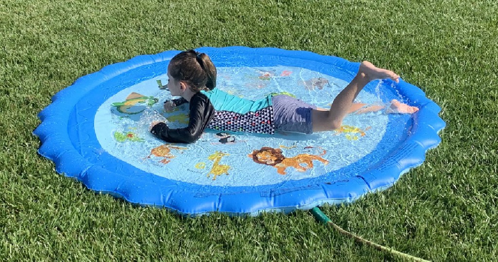 little girls laying on a bright blue splash pad