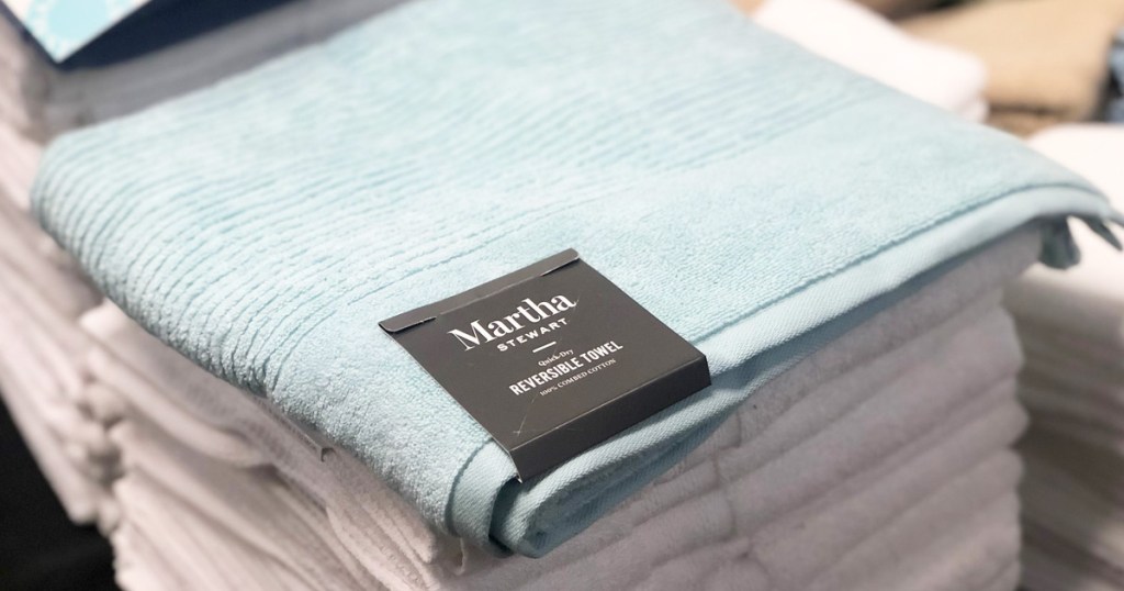 light blue Martha Stewart quick-dry bath towel on top of stack of folded white towels