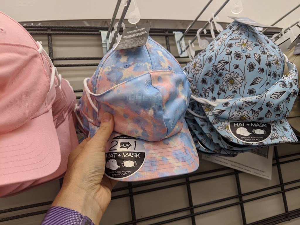 Hand showing off Mask hat combos in store