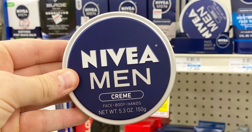 man holding up a blue colored round tin of Nivea Men's face and body creme