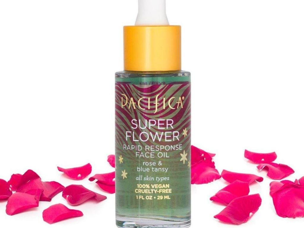 bottle of skincare oil with rose petals