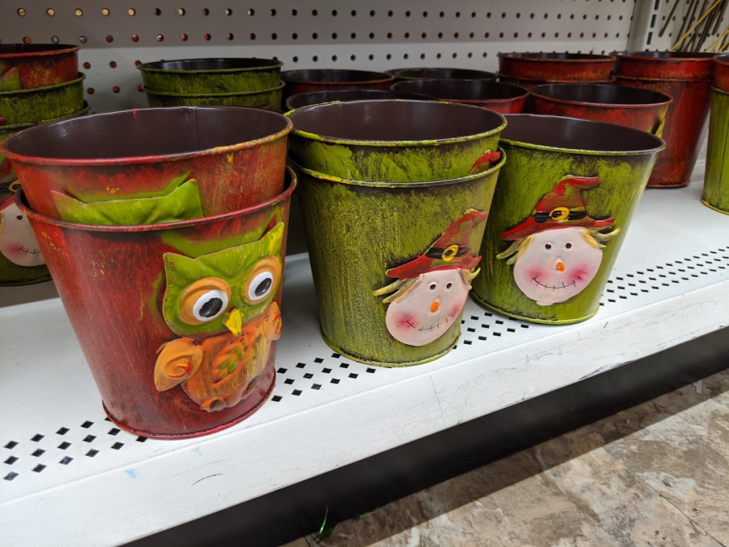 multiple Painted Iron Harvest Planter Buckets on shelf at dollar tree