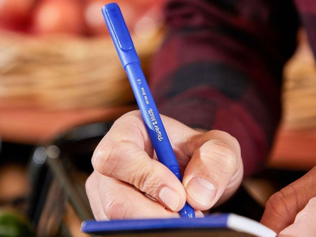 woman's hand holding a pen and taking an order