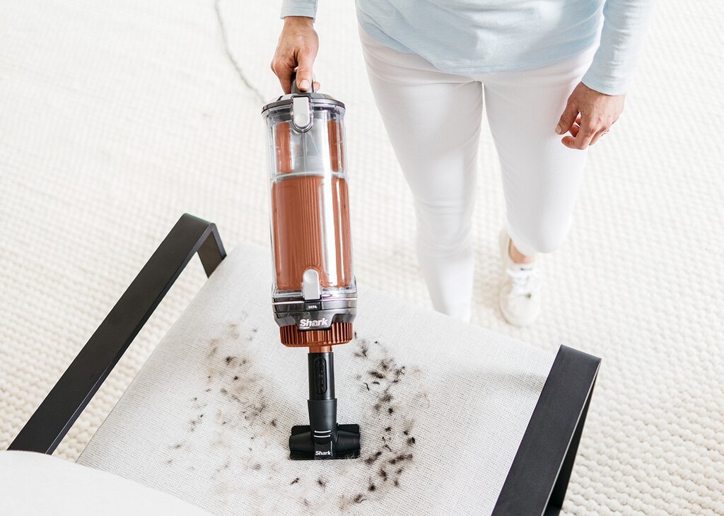 person vacuuming a chair