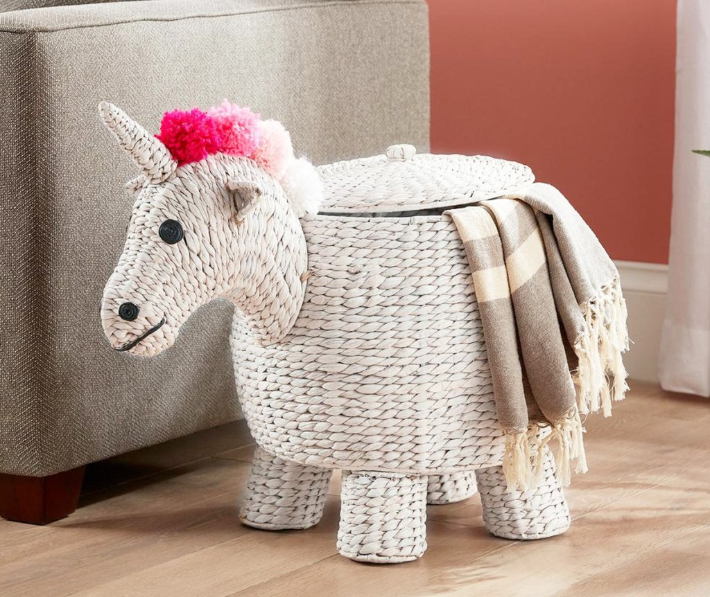 white unicorn sotrage basket with pink hair and blanket coming out from lid