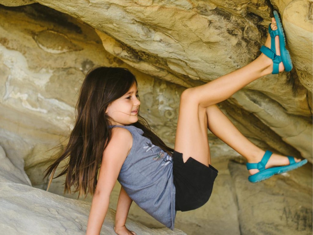 girl climbing rocks in cave