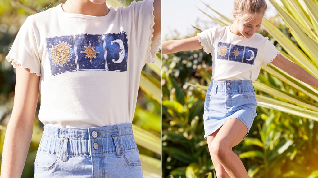 girl modeling a star and moon graphic tee with light wash denim skirt