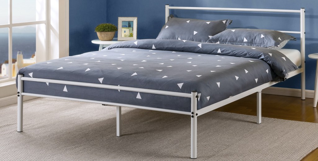 white bed frame and headboard with mattress with blue and white bedding