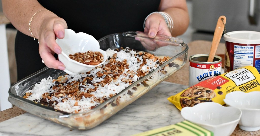 adding chopped pecans to magic cookie bars