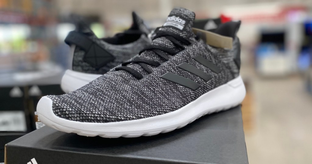 men's dark grey and white sneakers sitting on shoe box in store