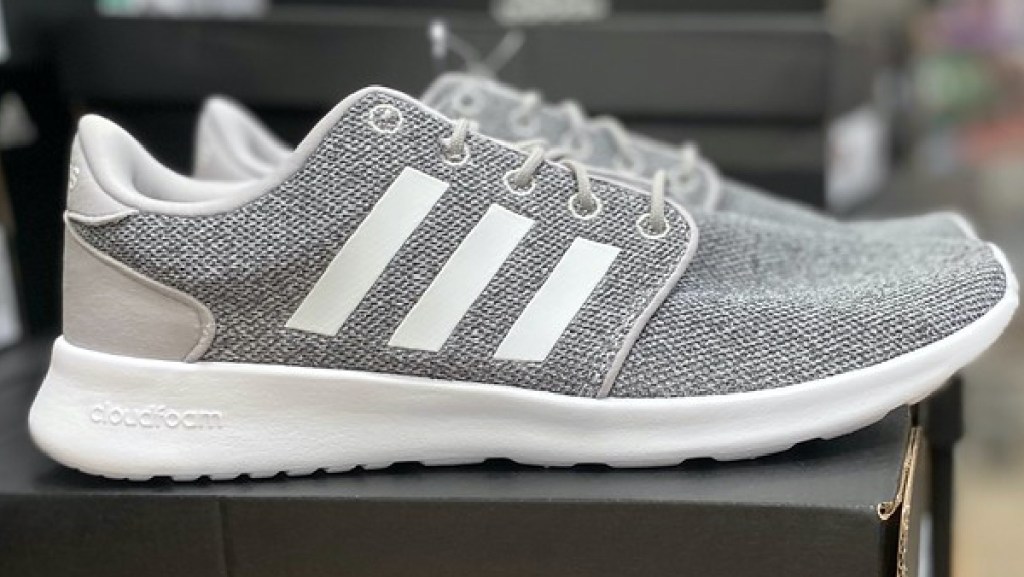 women's light grey and white sneakers sitting on shoe box in store