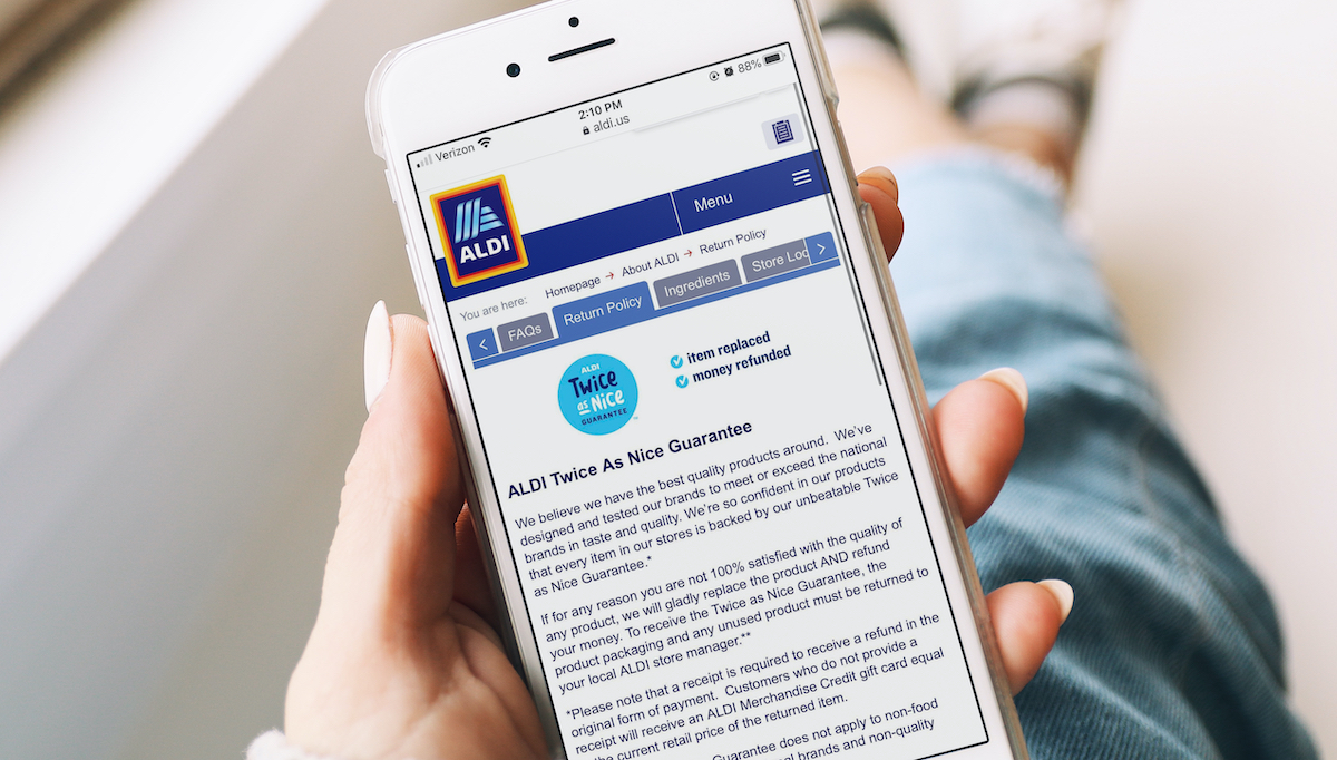 aldi shopping tips hand holding an iphone with aldi return policy on screen