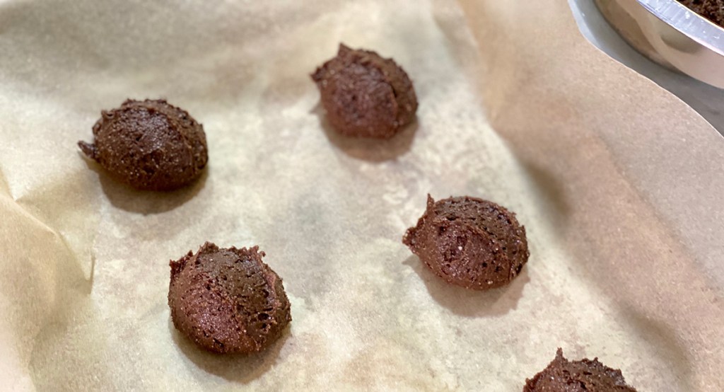 cookie dough mounds on parchment lined tray