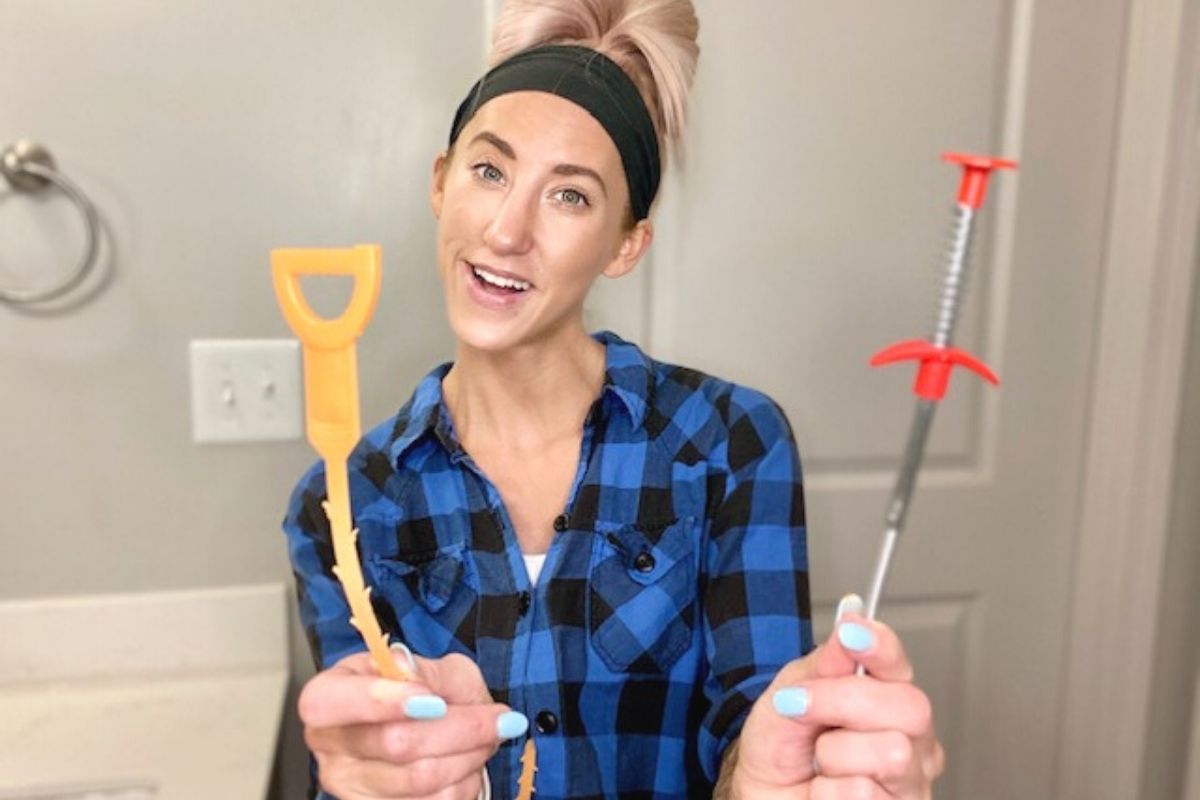 A woman holding drain clog tools