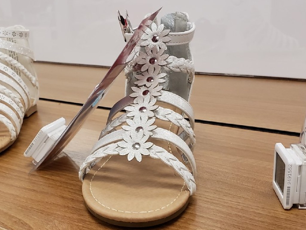 one white sandle sitting on store display with tags