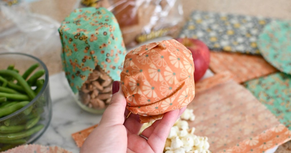 holding up an apple with beeswax wrap