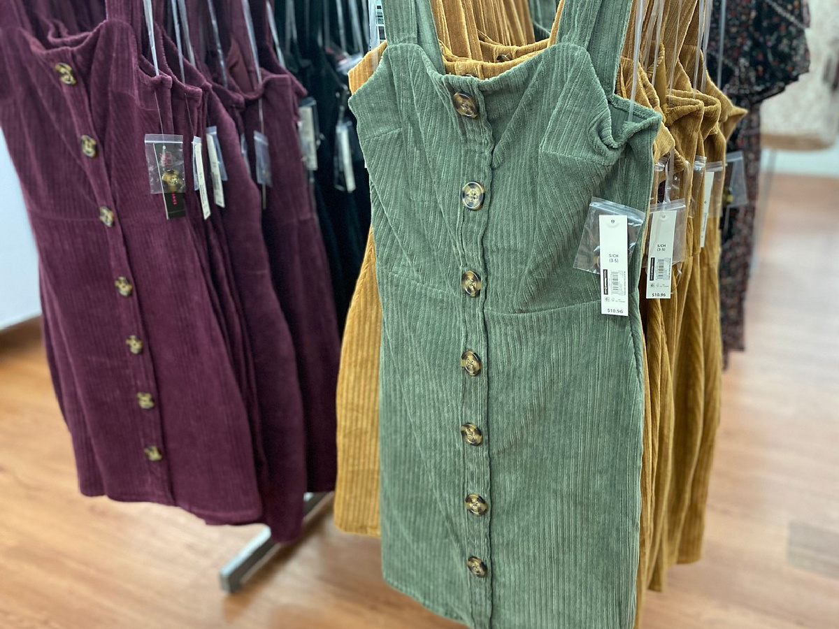 green, yellow and purple dress on hanger in store