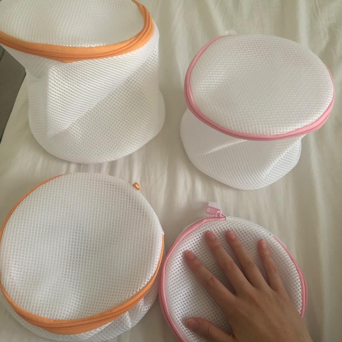 four cylindrical mesh laundry bags