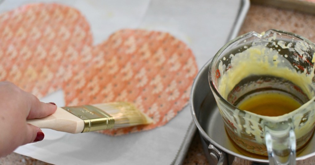 painting wax onto fabric for beeswax wraps