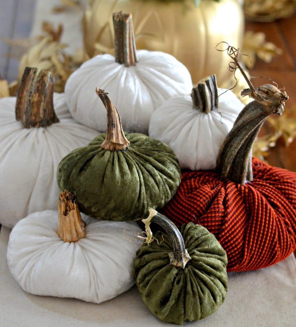 pile of velvet pumpkins in a stack on table