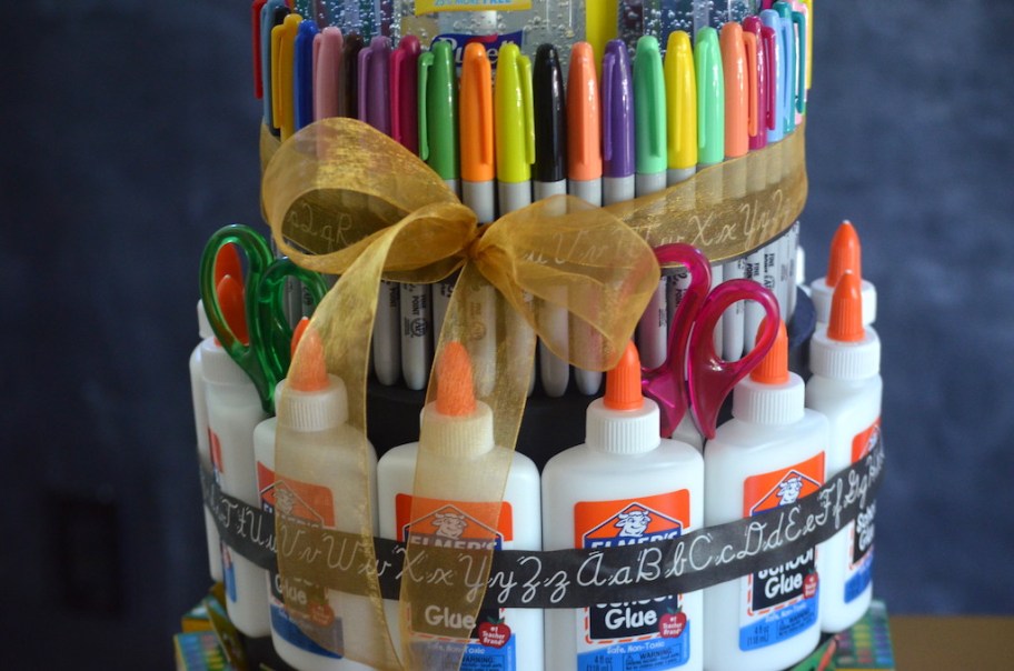 putting ribbon around school supply "cake" 