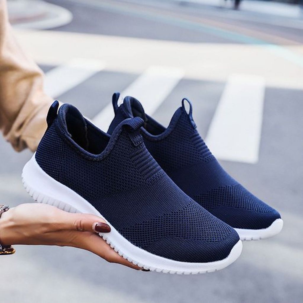 holding blue slip on shoes 