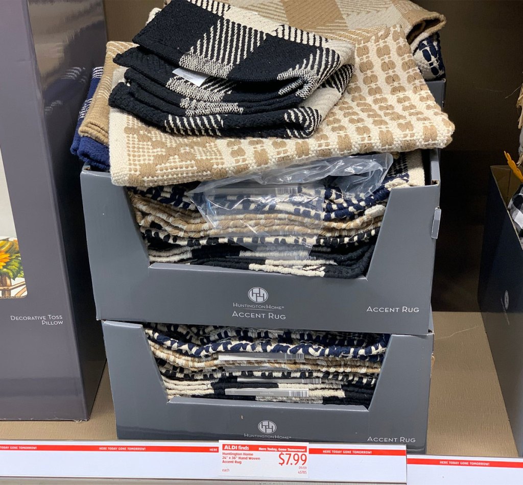 grey box of folded woven rugs on ALDI store shelf