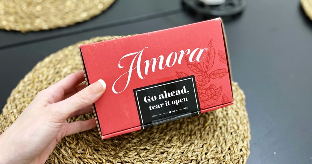 hand holding box of amora coffee