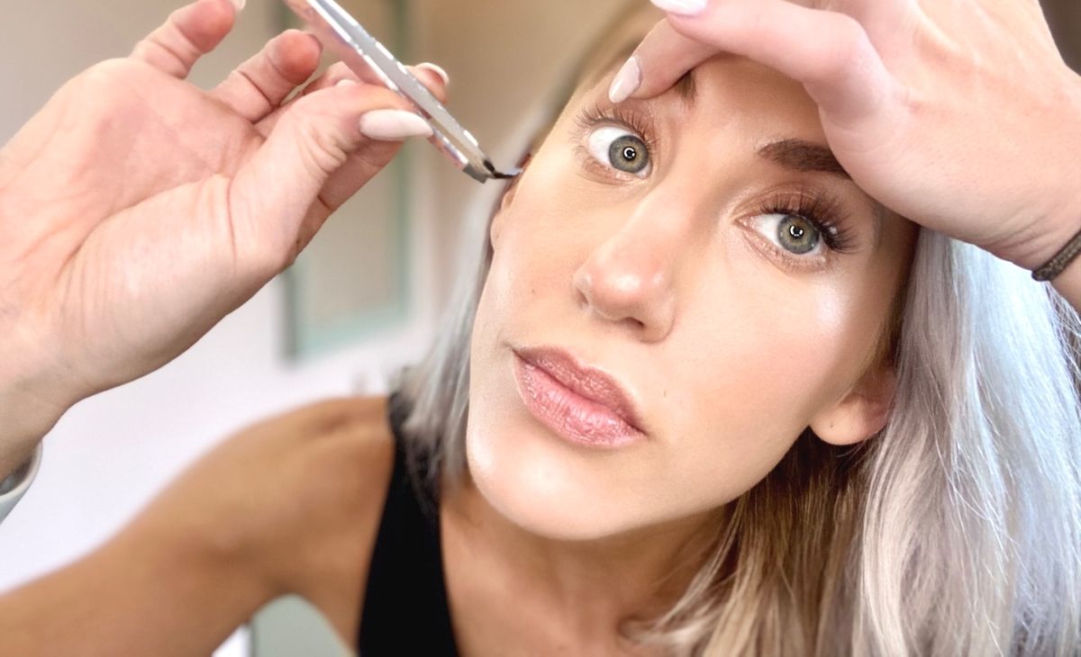 A woman applying false eyelashes