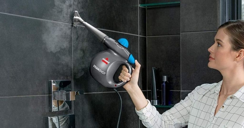 woman steam cleaning tiles