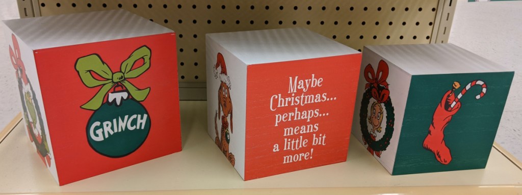 three Grinch Christmas boxes on store shelf