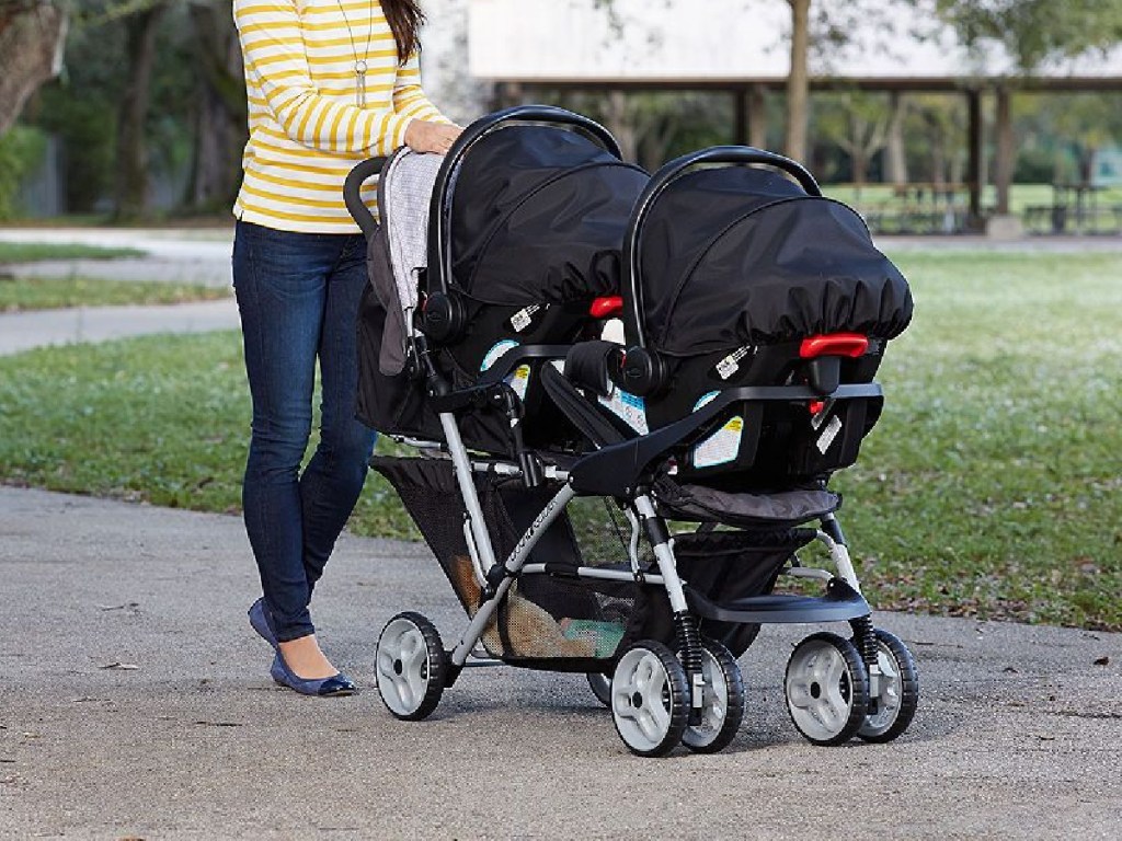 woman pushing double stroller outside