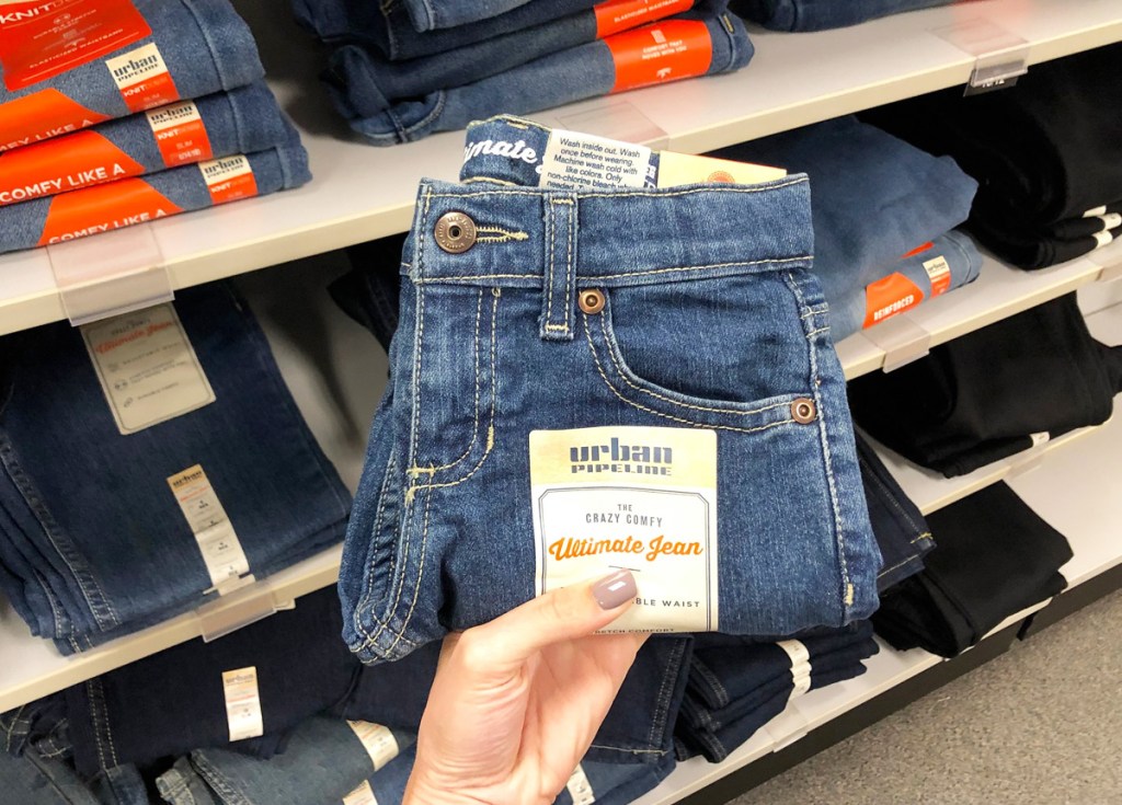 woman holding up pair of boys urban pipeline brand jeans