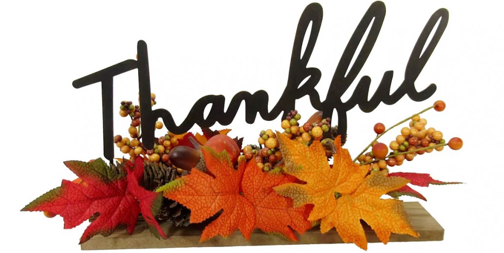 tabler decor piece with leaves and pumpkins that says thankful in black letters