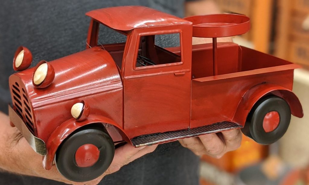 man holding red truck candle holder