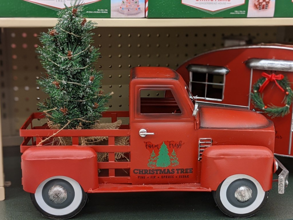 red truck with light up Christmas tree in bed decor on store shelf