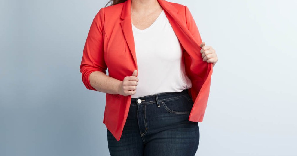 woman in white tee, jeans, and red blazer