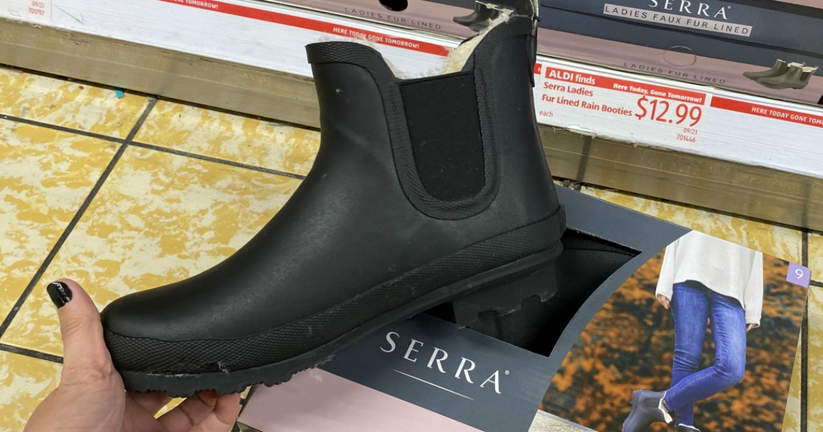 Women's rain boot in hand near box