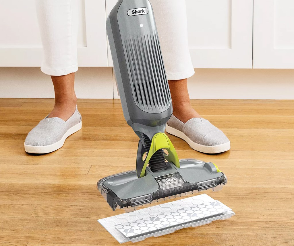 person replacing the mop pad on a shark vacmop on hardwood floor