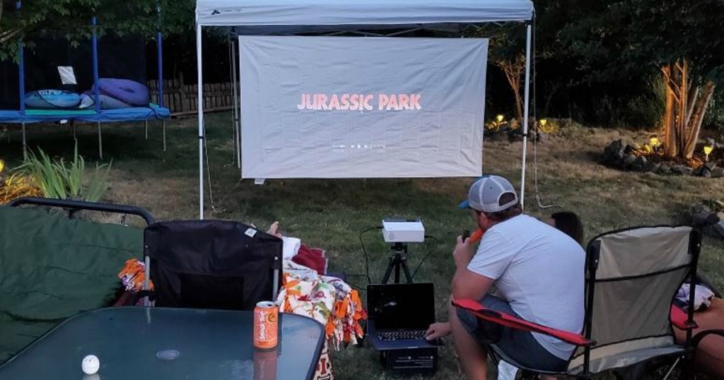 man watching Jurassic Park on projector screen