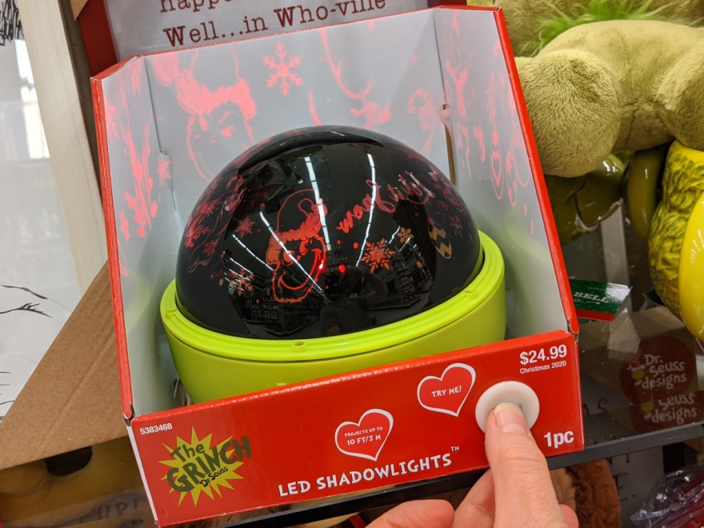 hand pressing button on Grinch light show projector in store