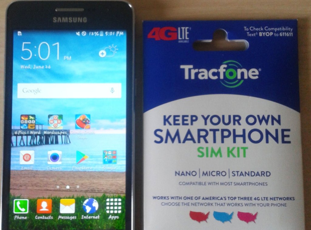 smartphone with Tracfone SIM kit next to it