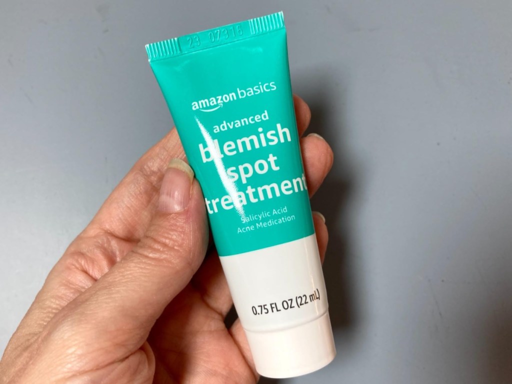 holding a tube of blemish treatment